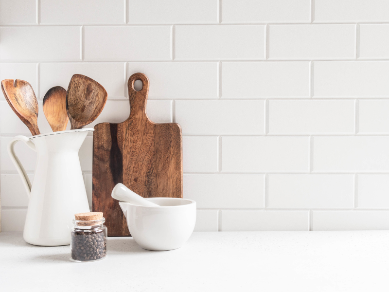Kitchen counter with wood cutting board and utensils crock