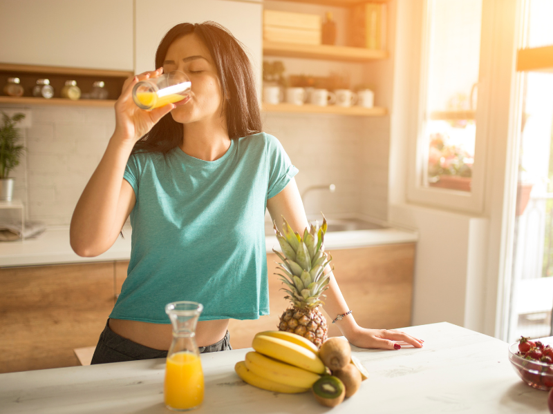 woman drinking fruit juice in kitchen