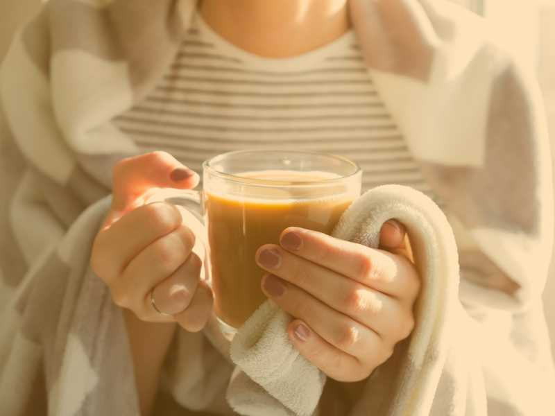 woman holding clear glass cup with coffee in it