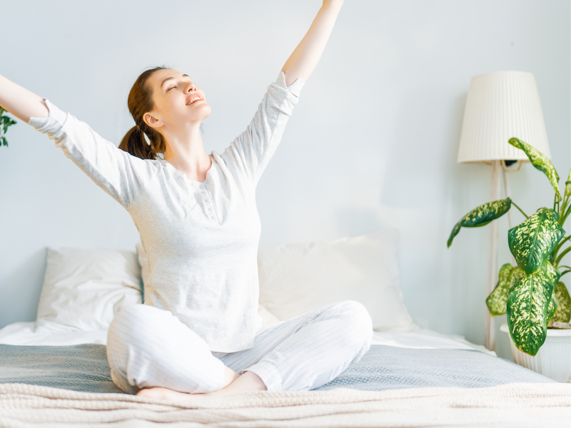 woman sitting on bed stretching