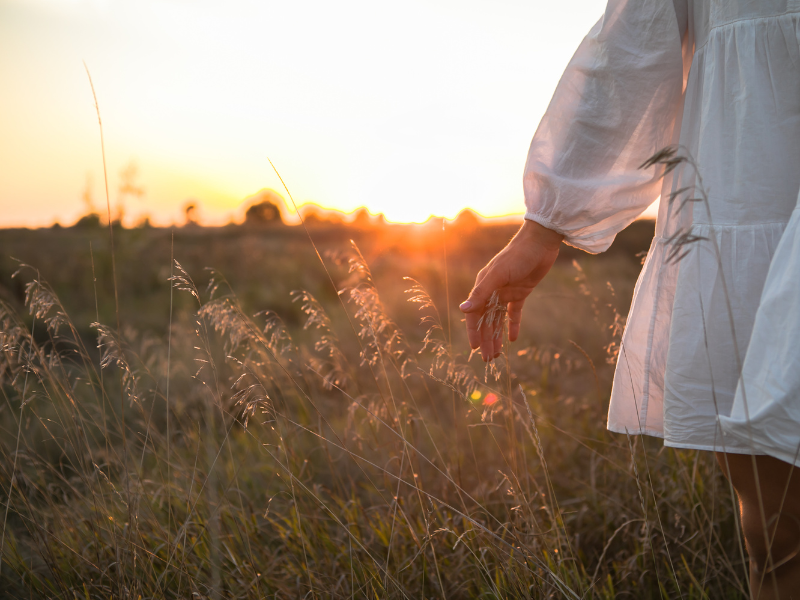 woman walking in grass sunshine